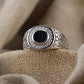 “Close-up of handcrafted S925 sterling silver Turkish ring with black onyx gemstone”Silver ring with black center stone on beige fabric