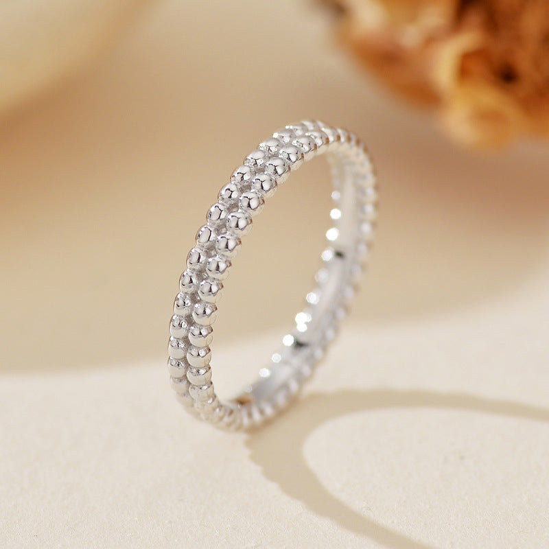 “Close-up of polished double beaded design on sterling silver minimalist ring”