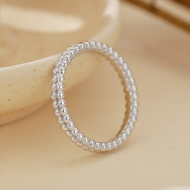 “Close-up of polished double beaded design on sterling silver minimalist ring”