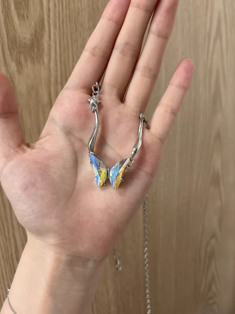 “Close-up of sculptural gradient butterfly pendant in polished sterling silver”