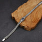 Silver bracelet with a blue gemstone on a wooden block against a dark background