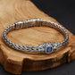 Silver bracelet with a blue gemstone on a wooden surface
