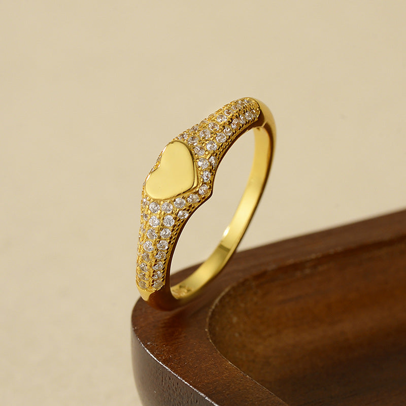 “Flat lay of S925 sterling silver heart signet ring with micro pave cubic zirconia”