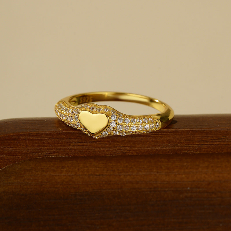 “Flat lay of S925 sterling silver heart signet ring with micro pave cubic zirconia”