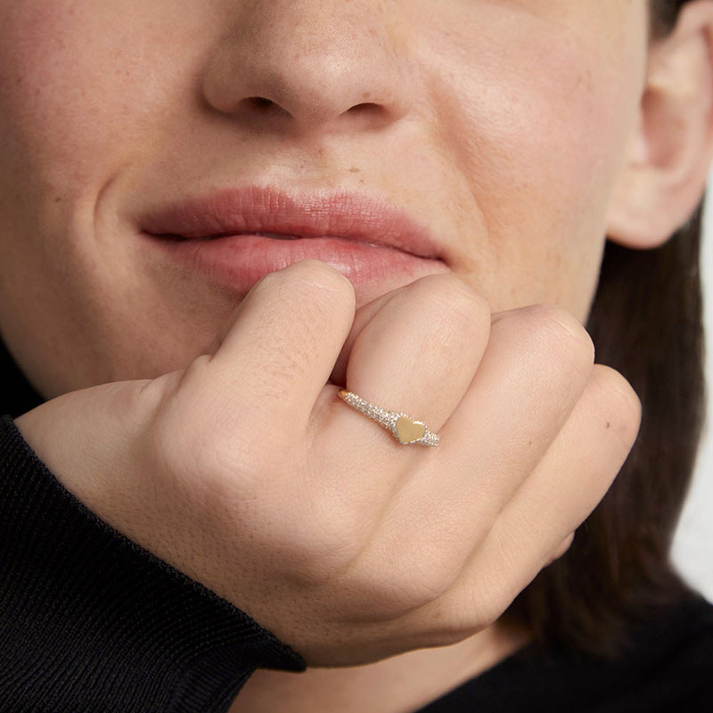 “Flat lay of S925 sterling silver heart signet ring with micro pave cubic zirconia”