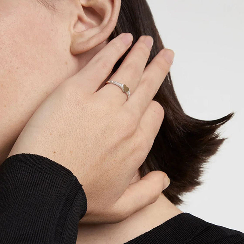 “Woman wearing minimalist silver heart ring with subtle sparkle”