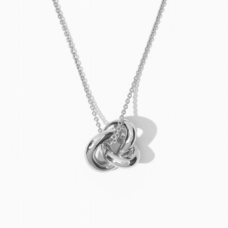 “Close-up of polished sterling silver interlocking circles pendant with smooth finish”