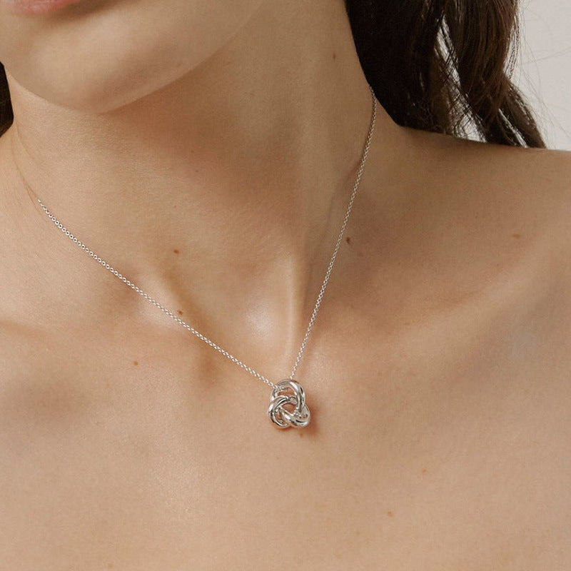 “Woman wearing minimalist silver interlocking rings necklace with elegant neckline”
