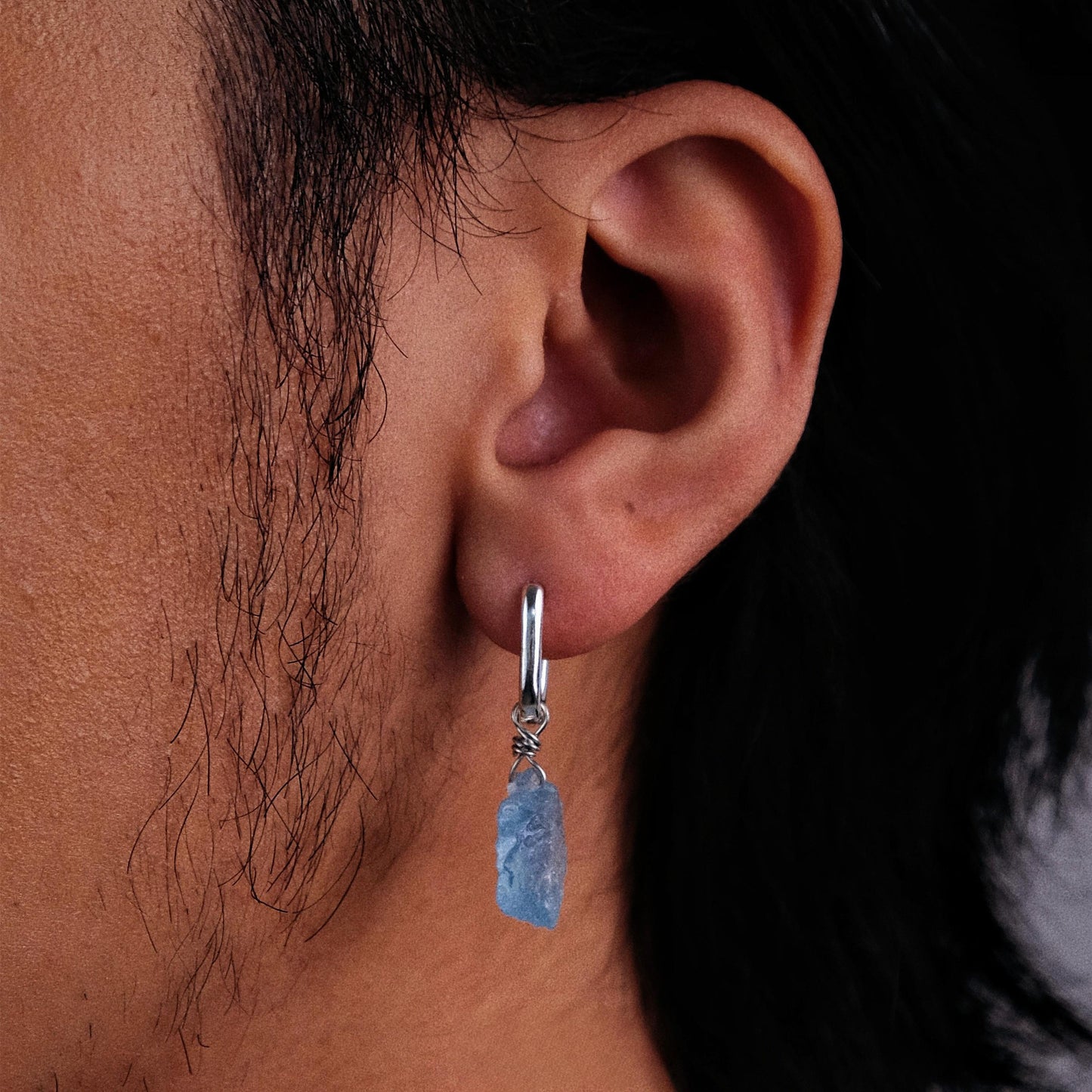 “Ocean-blue stone silver earrings worn by model in neutral outfit”