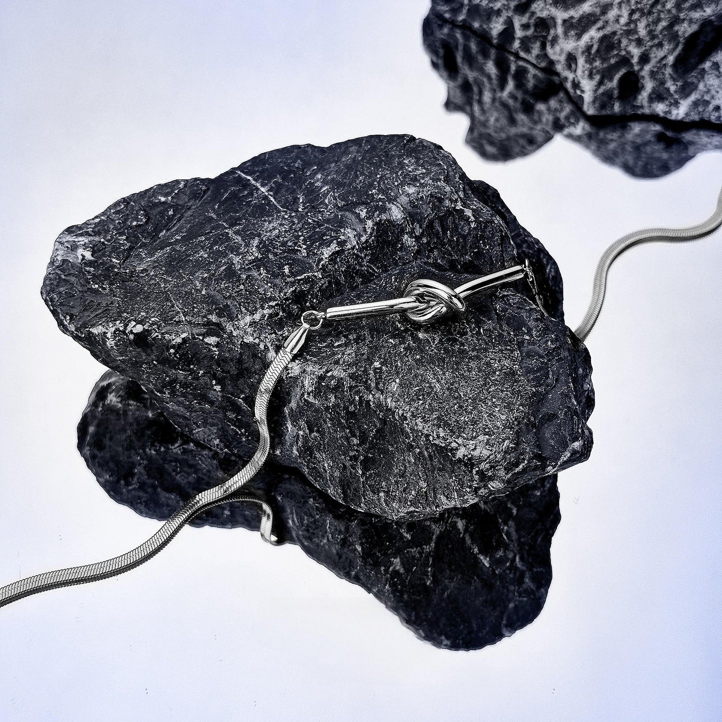 “Close-up detail of snake bone chain with sculptural knot design”