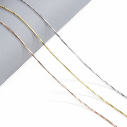 “S925 sterling silver mixed link necklace flat lay with box and bead chain details”Three gold chains of different thicknesses on a white and gray background