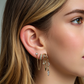 Close-up of a woman's ear wearing multiple gold earrings with gemstones.S925 Sterling Silver Nyx Stars & Moon Earrings