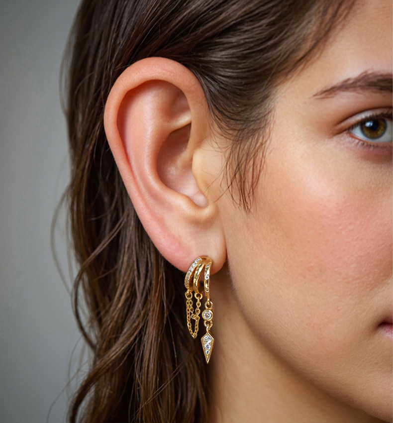 Close-up of a woman's ear wearing gold hoop S925 Sterling Silver Palma Charm Earring with dangling charms.