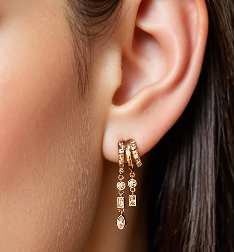 S925 Sterling Silver Petra Stacked Illusion EarringsClose-up of an ear wearing gold hoop earrings with dangling charms.
