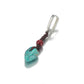 “Close-up of raw turquoise and cinnabar gemstone setting in sterling silver”