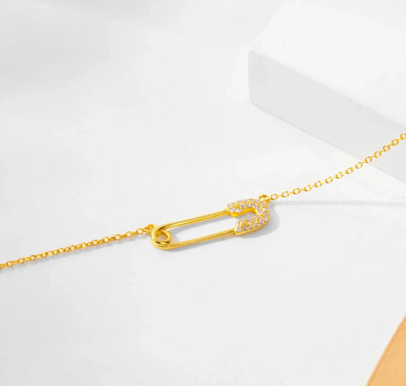 “Close-up of micro-pavé zircon safety pin pendant in polished silver finish”