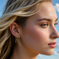 Close-up of a woman wearing gold S925 Sterling Silver Sienna Earrings with a blue sky background
