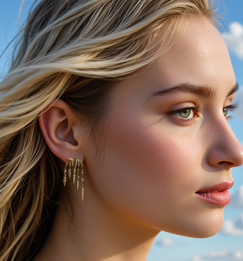 Close-up of a woman wearing gold S925 Sterling Silver Spike Stud Earrings with a blue sky background
