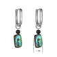 Pair of hoop earrings with green shell and black bead accents on a white background