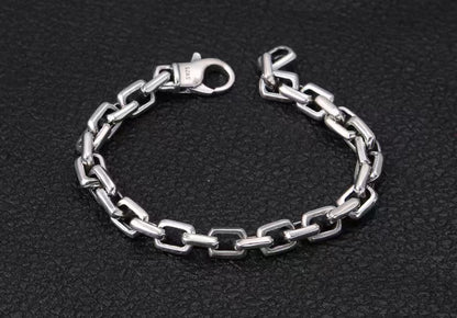 Silver chain bracelet on a black textured background