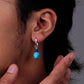 “Unisex Tibetan-style turquoise lapis earrings worn by model”