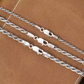 Silver rope chain on a brown leather surface