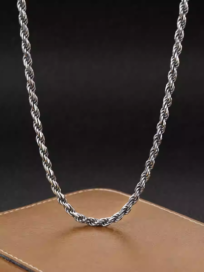 Silver rope chain necklace on a dark background