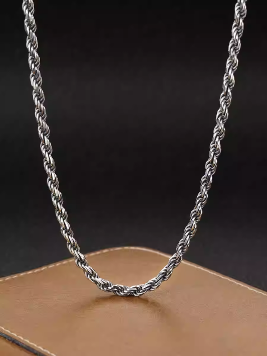 Silver rope chain necklace on a dark background