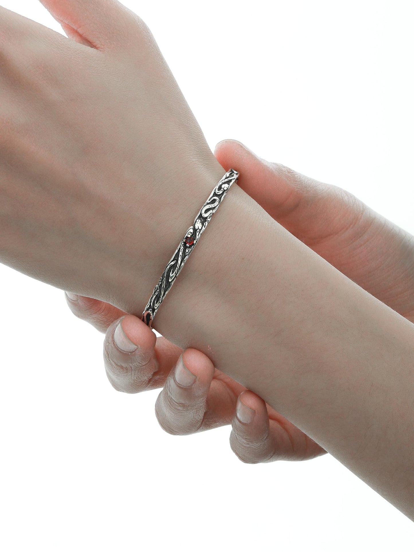 "Close-up of snake-inspired sterling silver bangle with tarnish-free polished texture"