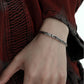 "Model wearing sleek unisex silver serpent bracelet styled in minimalist fashion"