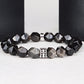 Black beaded bracelet with a silver clasp on a white surface
