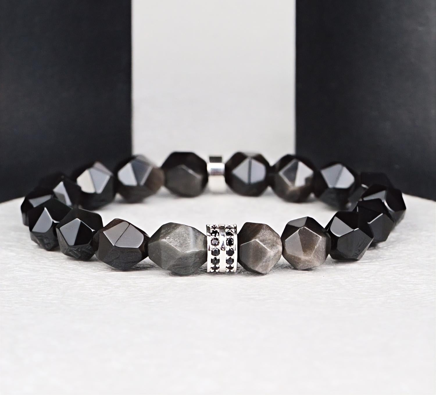 Black beaded bracelet with a silver clasp on a white surface