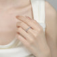 Close-up of a hand wearing a silver ring on a neutral background
