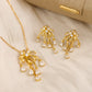 Gold jewelry set with necklace and earrings on a beige fabric background