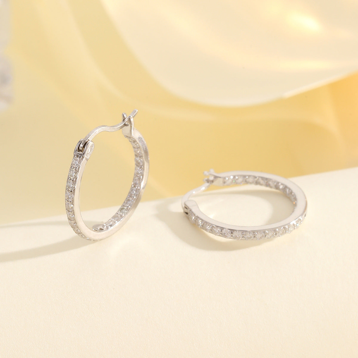 Yellow gold 1.4mm moissanite hoops on neutral background. Alt: “1.4mm Moissanite Hoop Earrings – 18K Yellow Gold.”