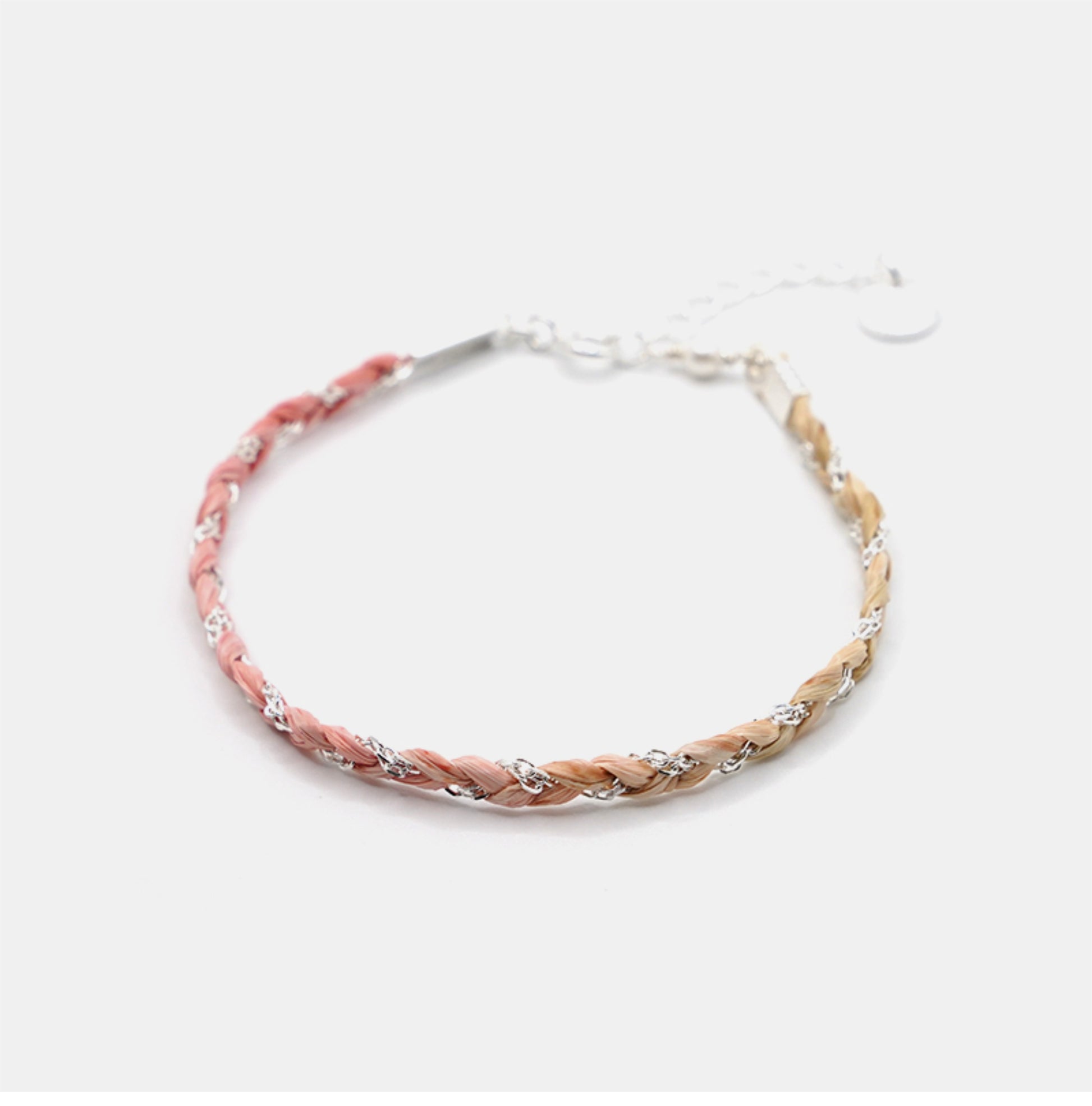 Braided bracelet with pink and beige strands on a white background