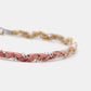 Braided bracelet with pink and beige strands on a white background