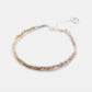 Braided bracelet with pink and silver tones on a white background