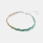 Bracelet with green and beige braided design on a white background