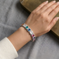 Include close-up shots showing the rainbow colors against the skin and wider shots showing the bracelet as part of an outfit.