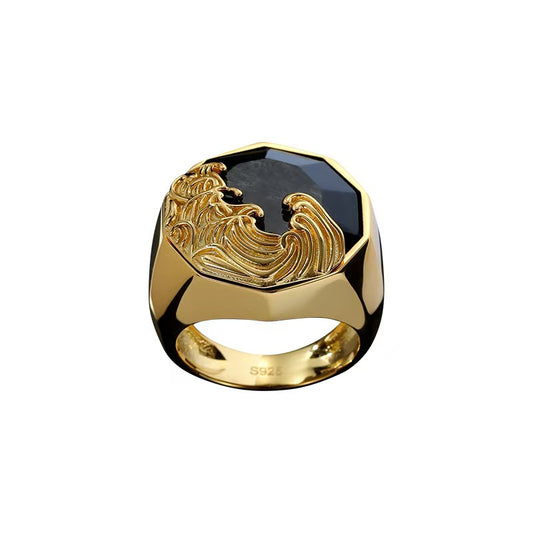 Gold ring with a black stone and eagle design on a white background
