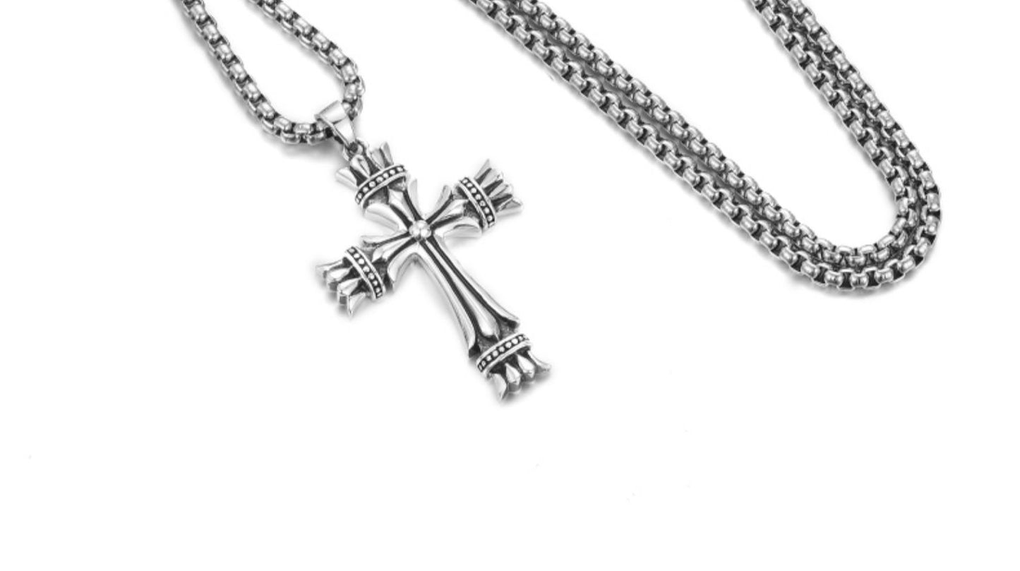 “Textured cross pendant showing craftsmanship and silver detailing”