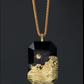 Gold and black pendant necklace on a dark background