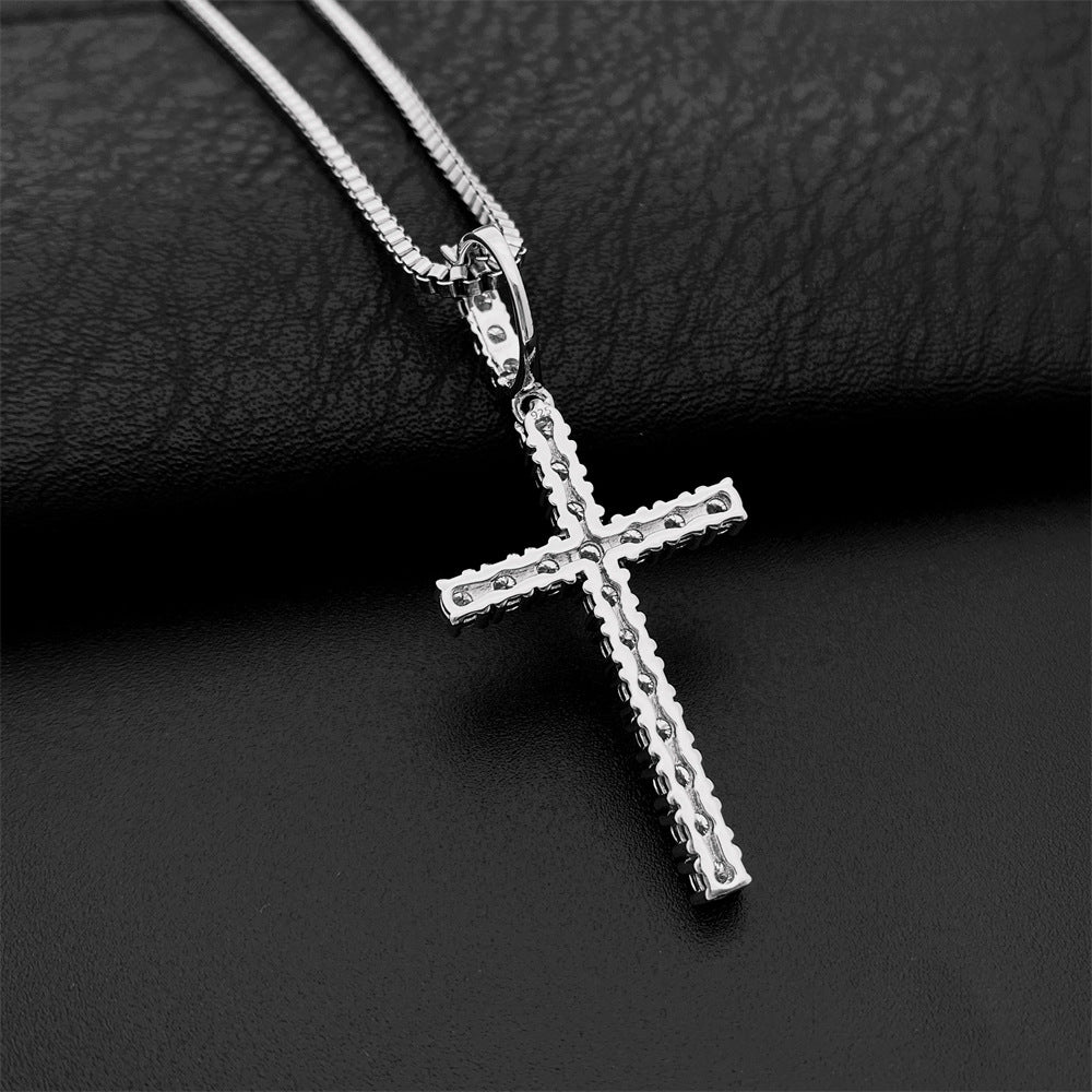Silver cross pendant necklace on a dark textured surface