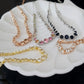 Set of necklaces with different designs on a white dish