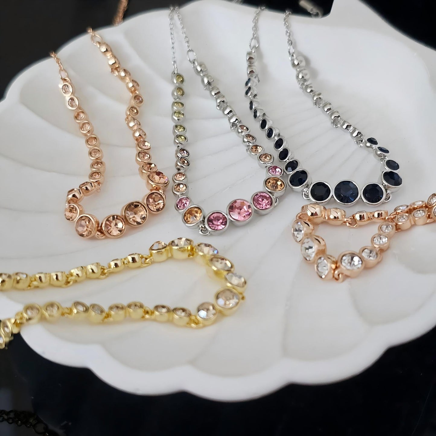 Set of necklaces with different designs on a white dish