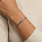 Bracelet with blue stones on a wrist against a beige background
