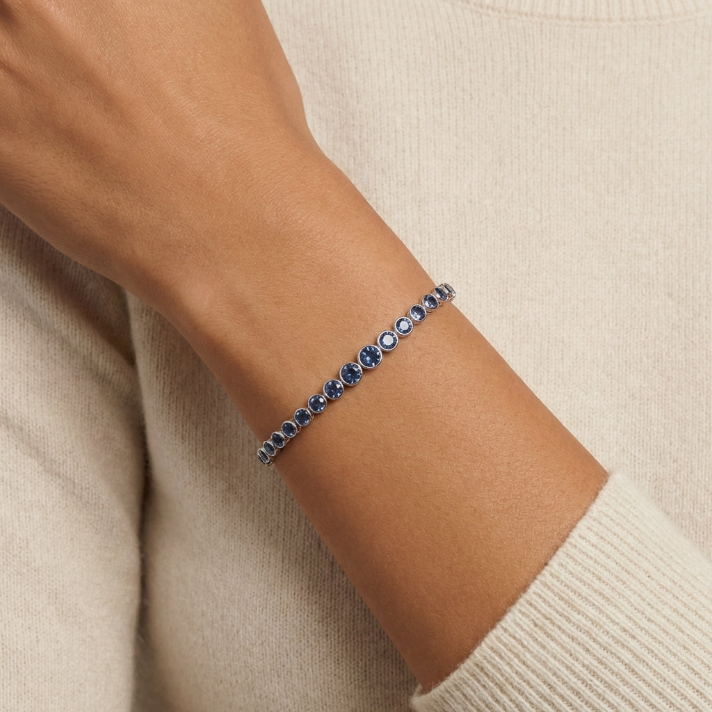Bracelet with blue stones on a wrist against a beige background