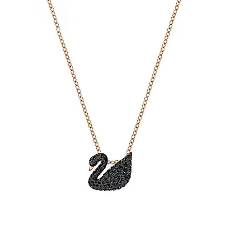 Swarovski Iconic Swan pendantBlack swan-shaped pendant on a gold chain against a white background