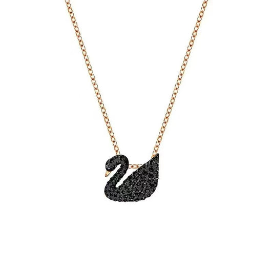 Black swan pendant necklace on a rose gold chain against a white background